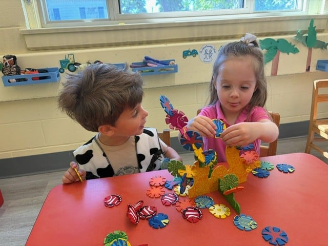 3s Cara 8 Young children playing with colorful foam animal figures at St. John's Nursery School.